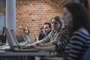 Zdjęcie. Kilka osób pracuje przy komputerach.
